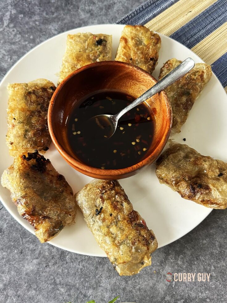 rice paper dumplings on a serving plate with spicy soy and oyster sauce.
