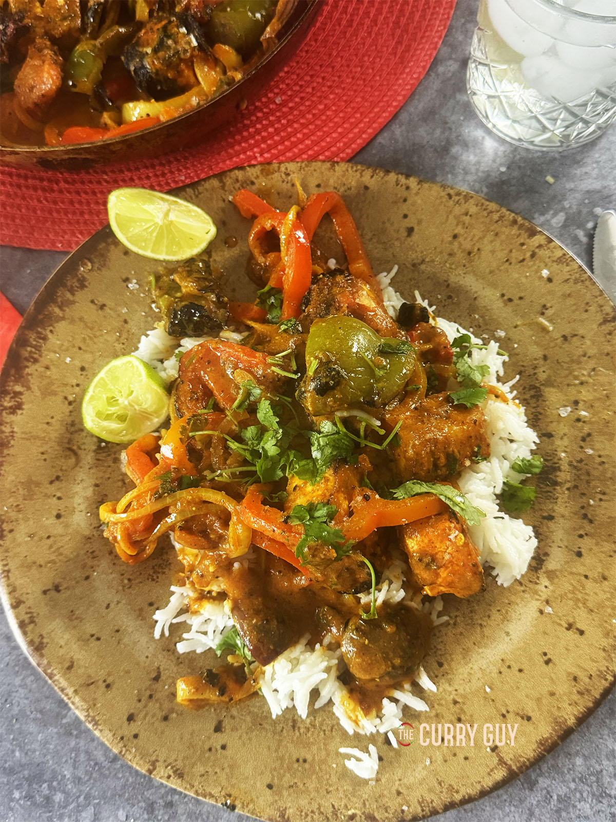 Paneer jalfrezi over rice on a serving plate.