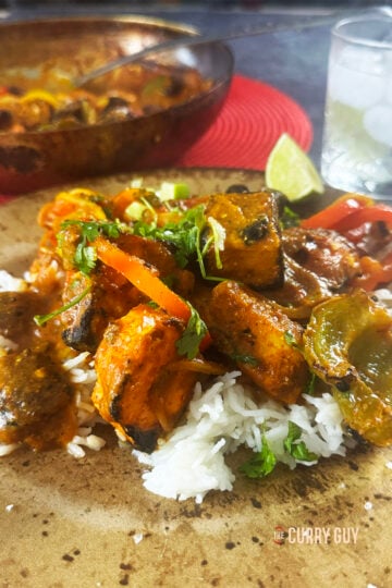 Paneer jalfrezi on a serving plate over rice.