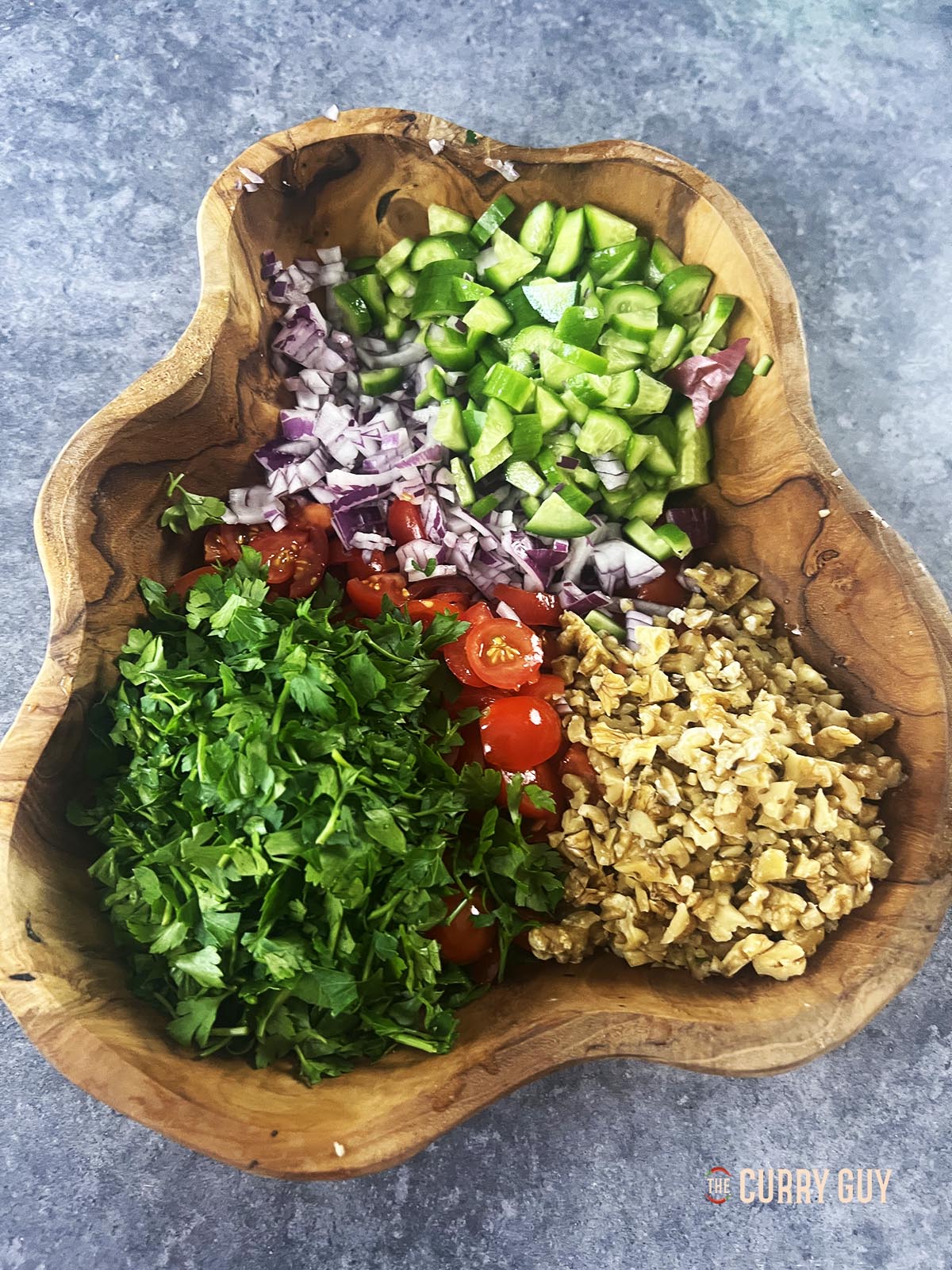 The salad ingredients in a salad bowl, chopped up and ready to mix with the dressing. 