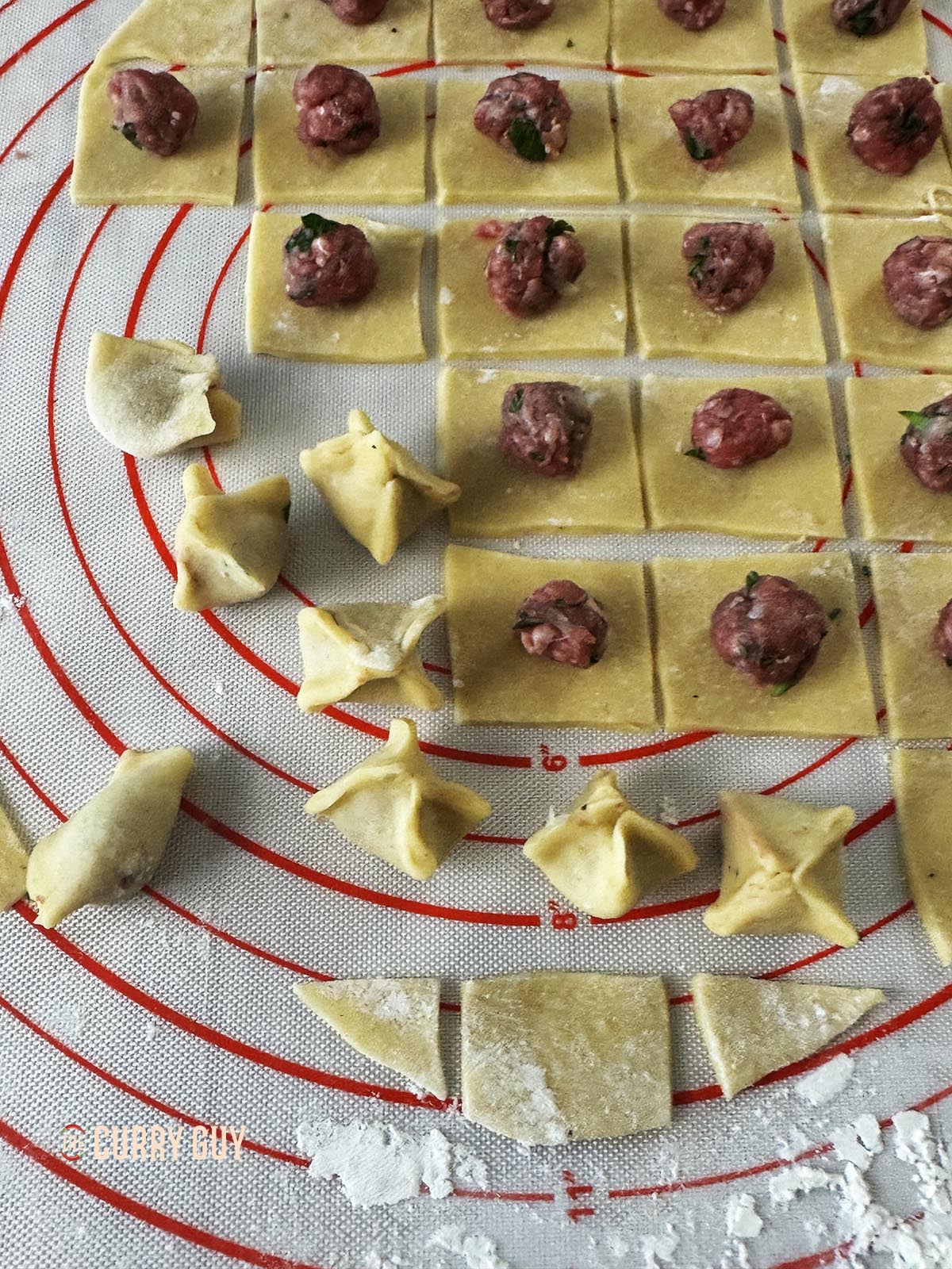 Making the manti by bringing the corners of each pasta square to the centre and squeezing the seams closed.
