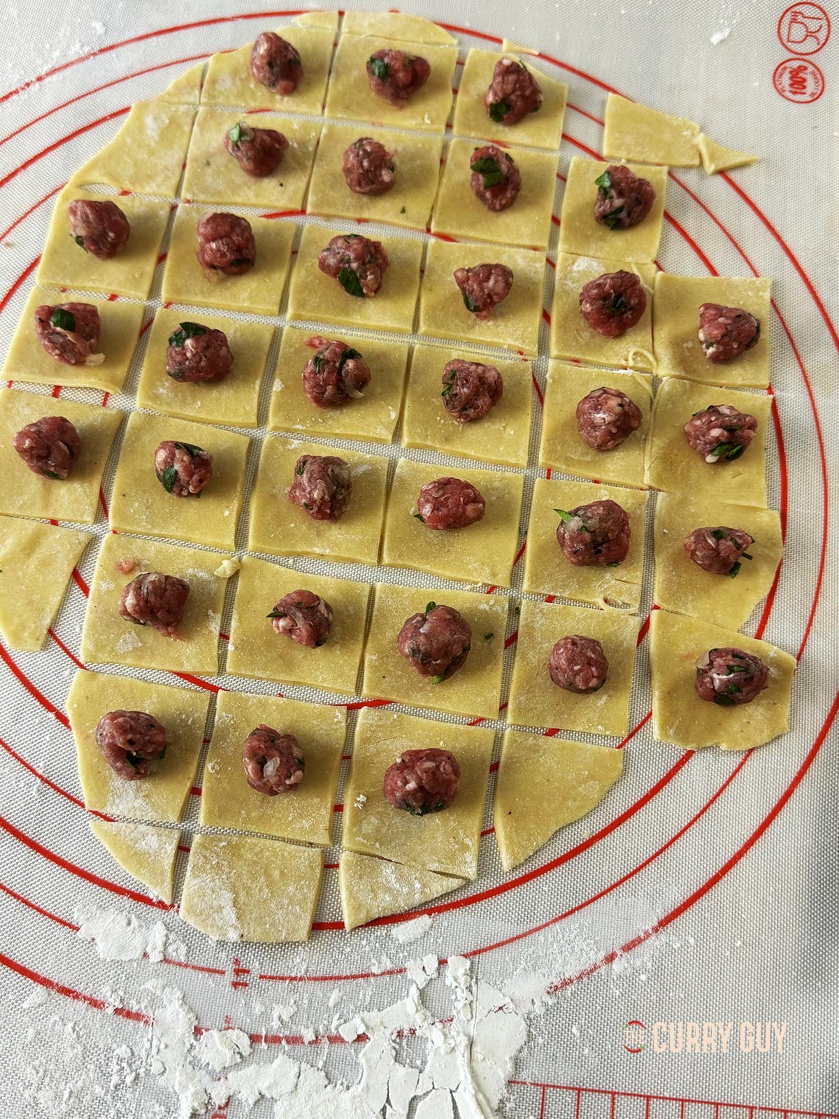 Adding the meat mixture to the pasta squares.