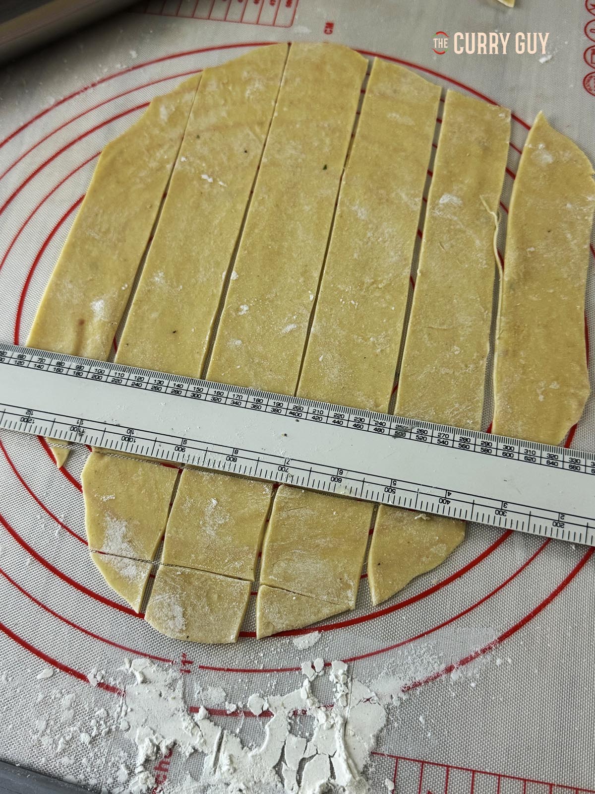 Rolling out and dividing the dough into squares for the dumplings.