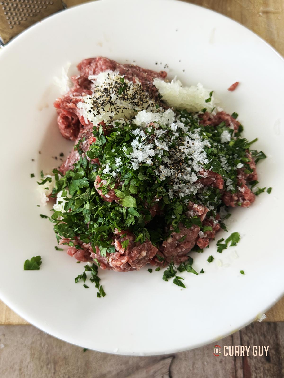 Mixing the meat with the grated onions, salt, pepper and chopped parsely.