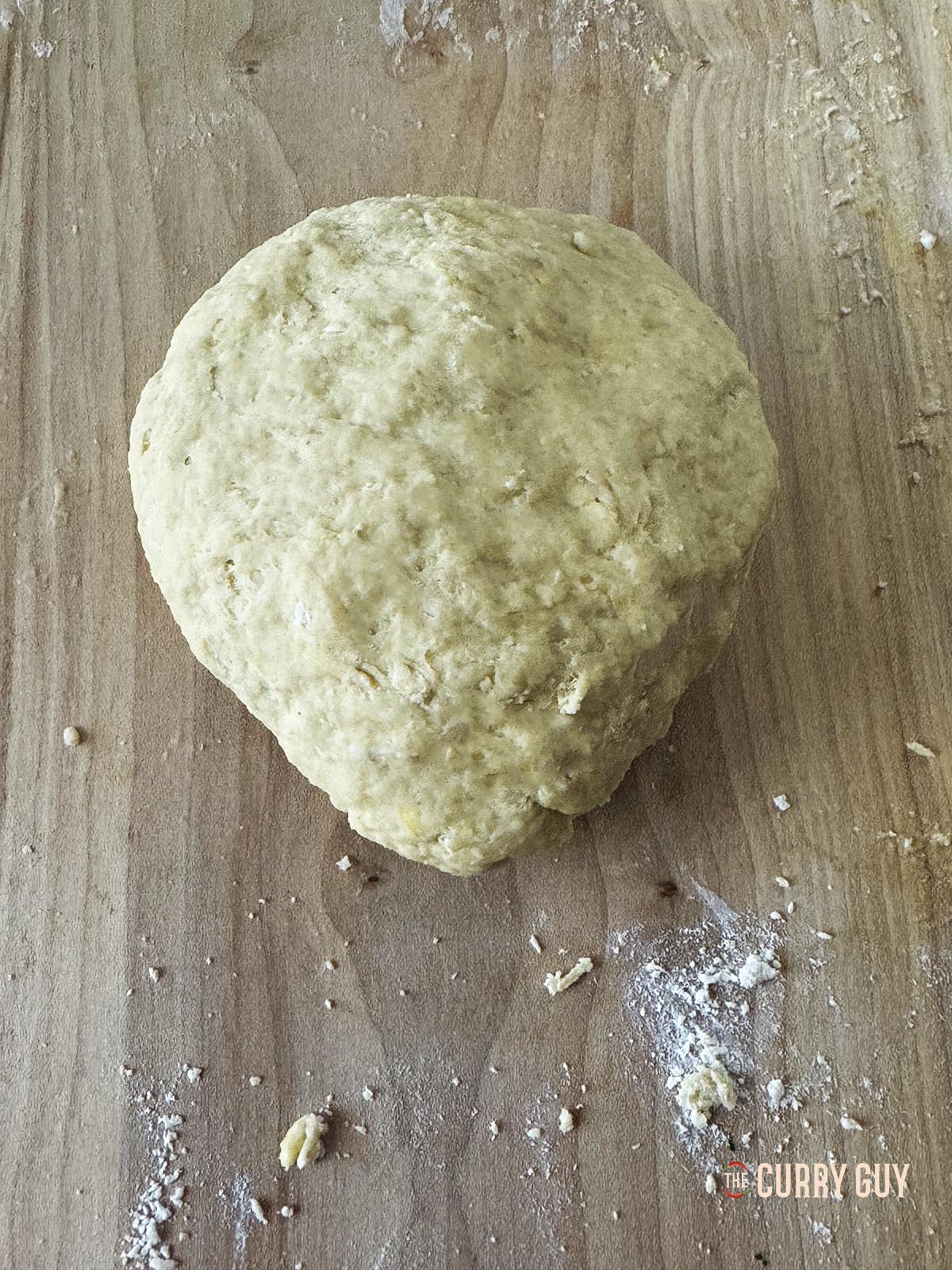 Adding water to the flour, salt and eggs to form a pasta dough.