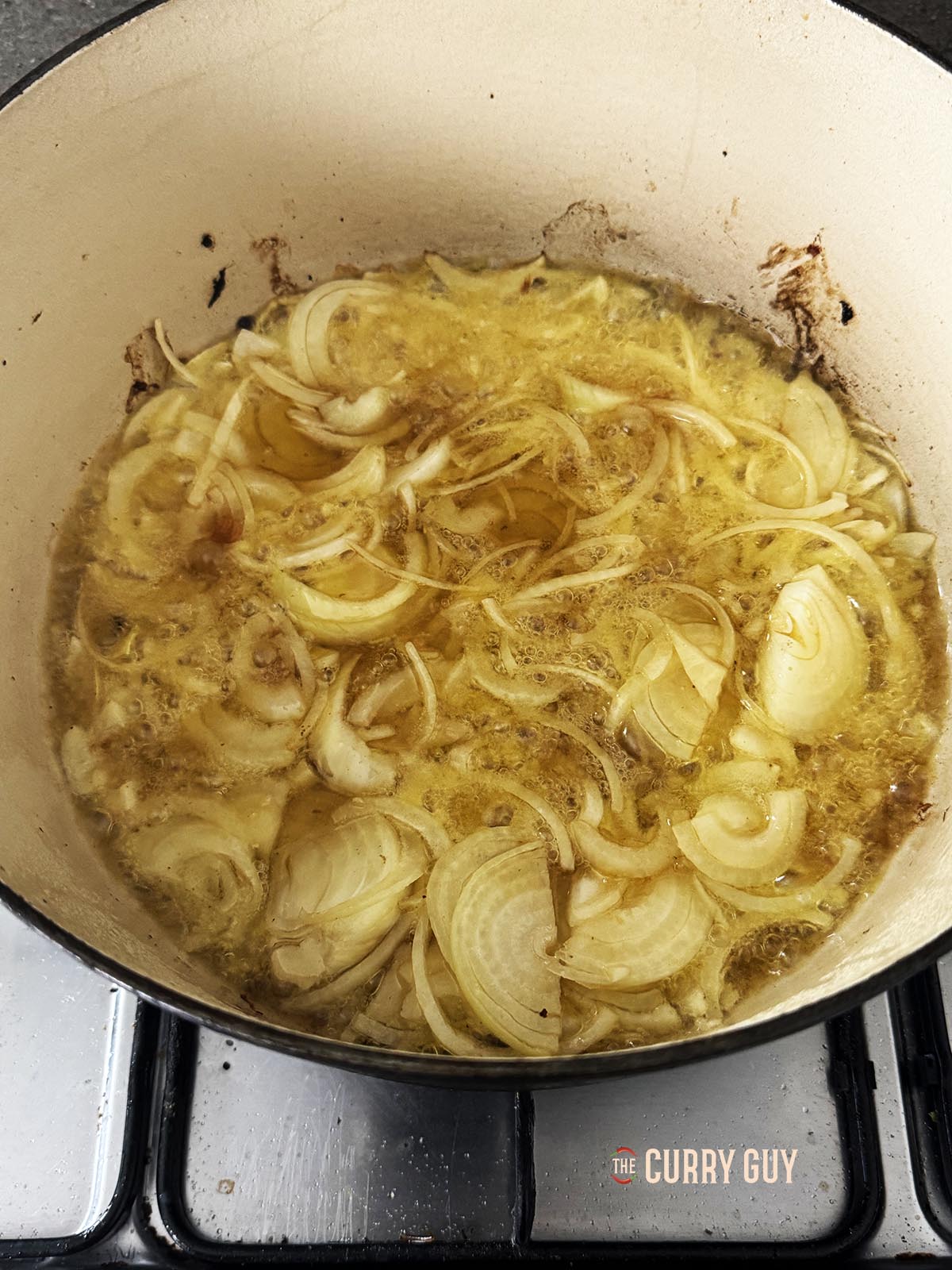 Frying the sliced onions in the oil and ghee.