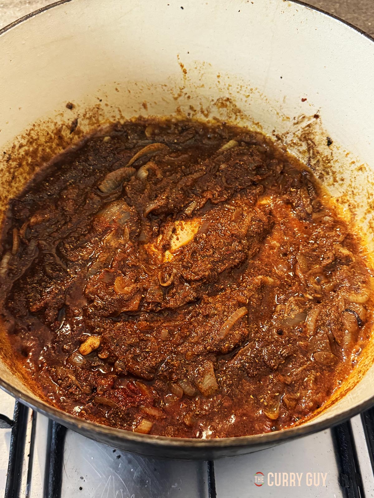 Adding water to the pot to make a thick spice paste.