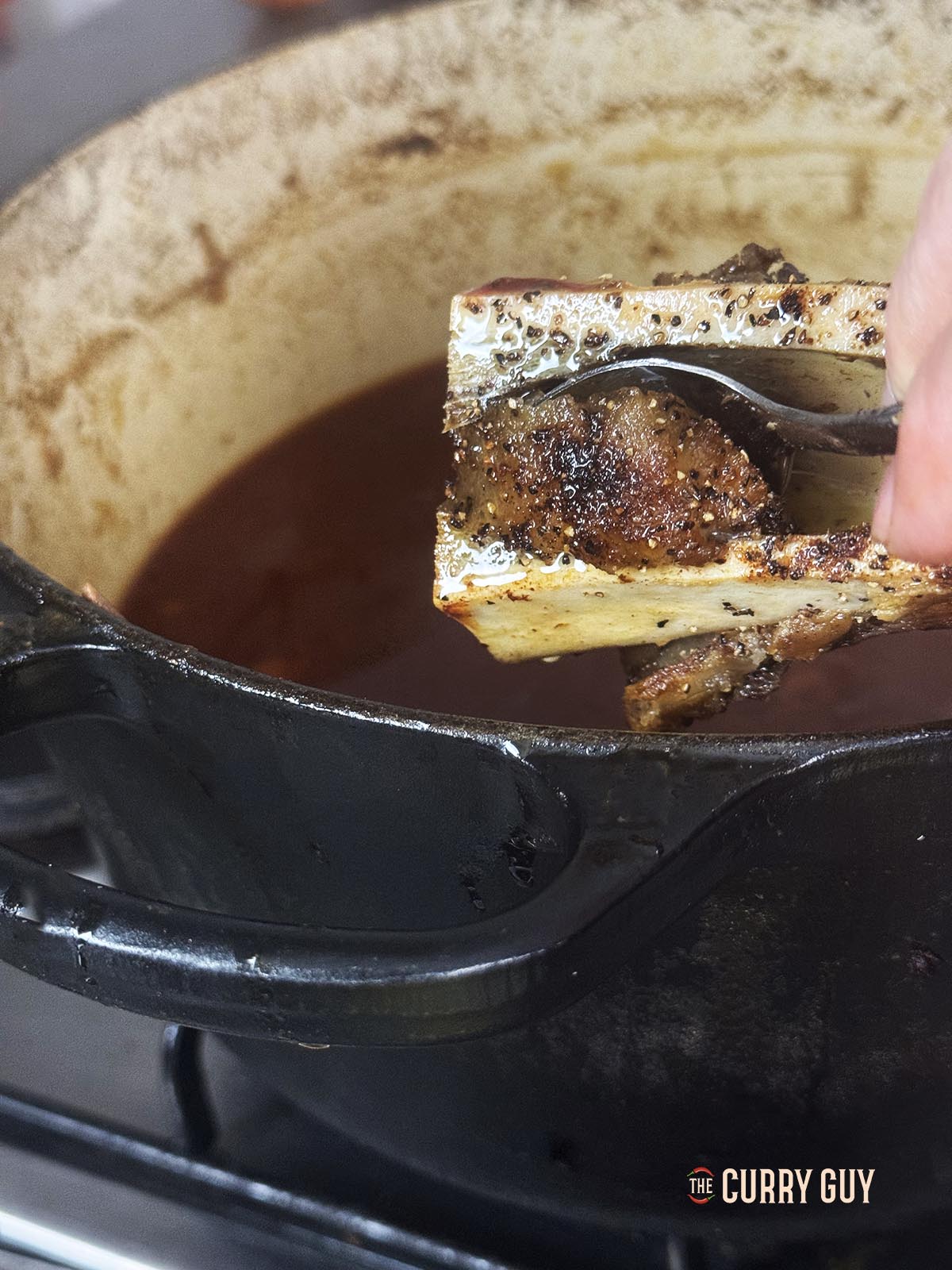 Adding roasted bone marrow to the sauce.