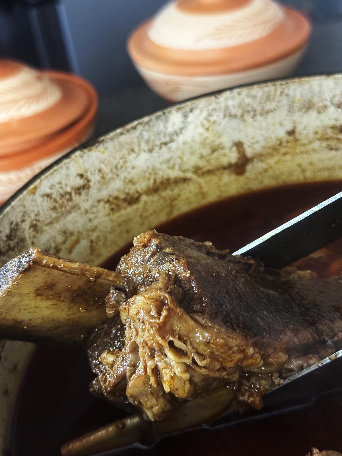 removing the meat and bones from the pot to chop into smaller pieces.