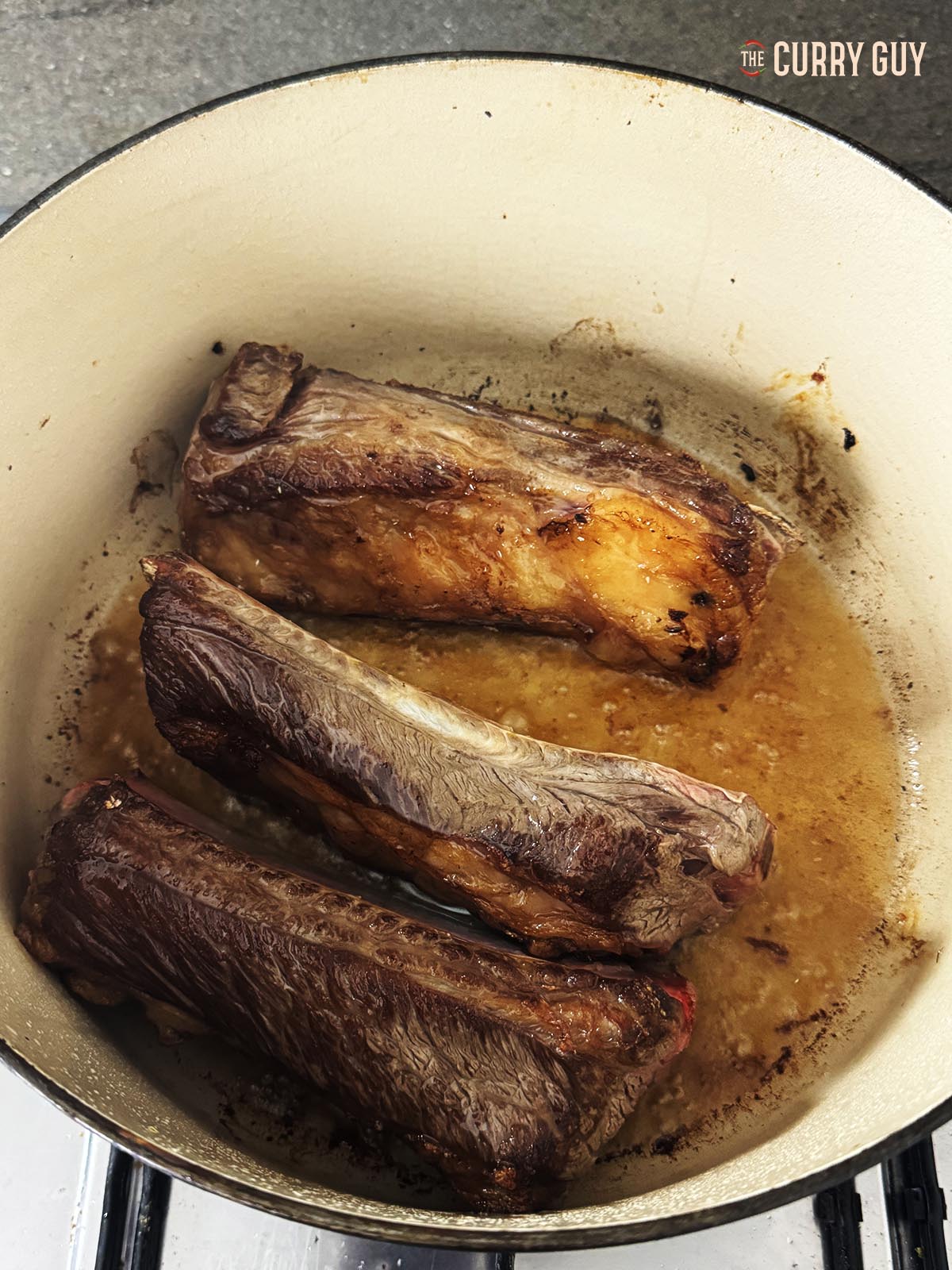 Browing three of the short ribs in a pot.
