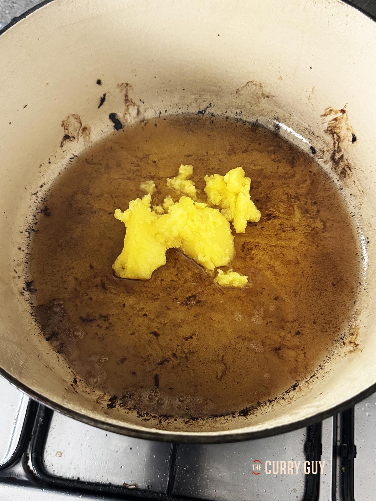 Adding ghee to the oil in the pan.
