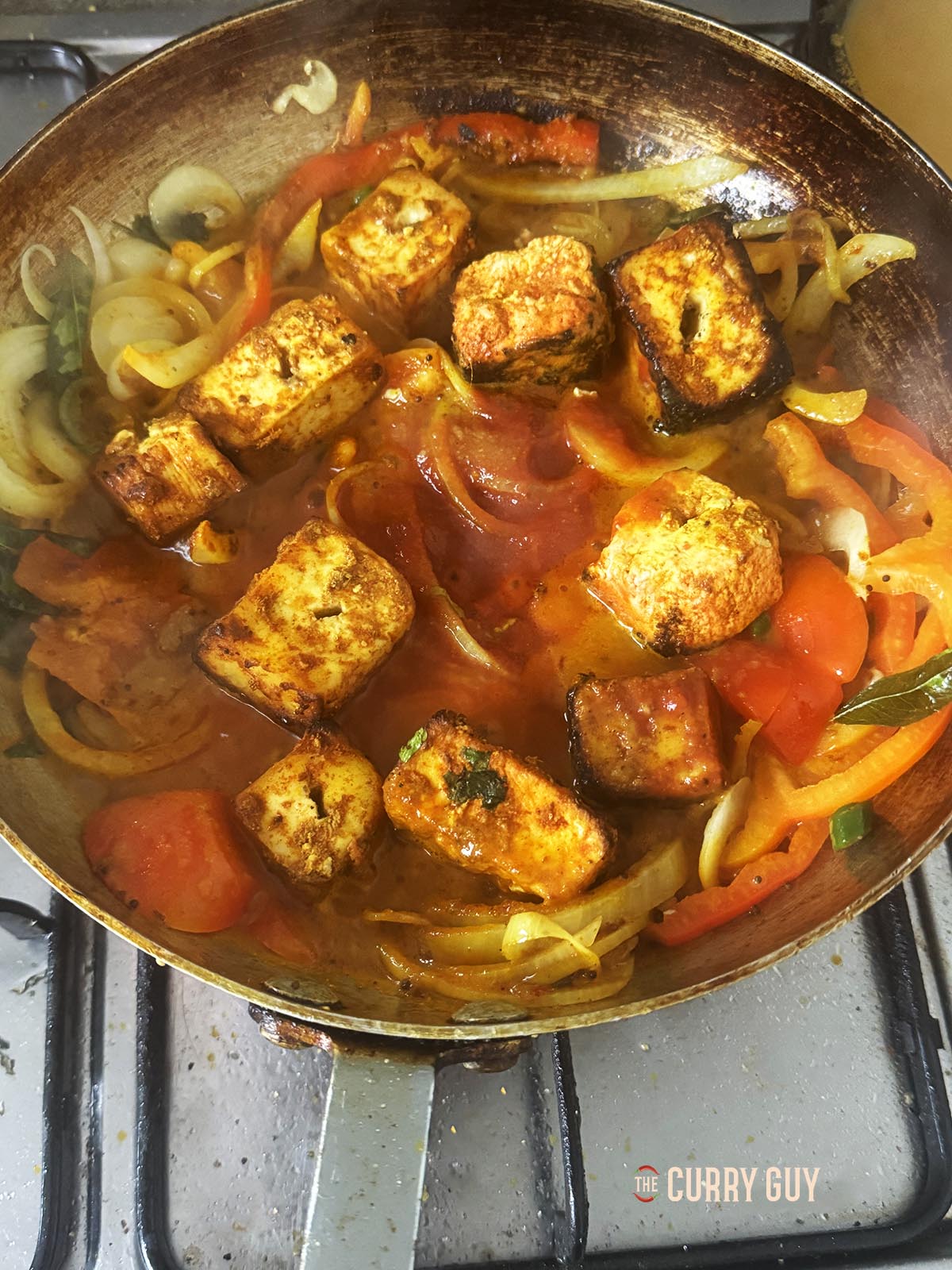 Adding the paneer and more base to the pan.