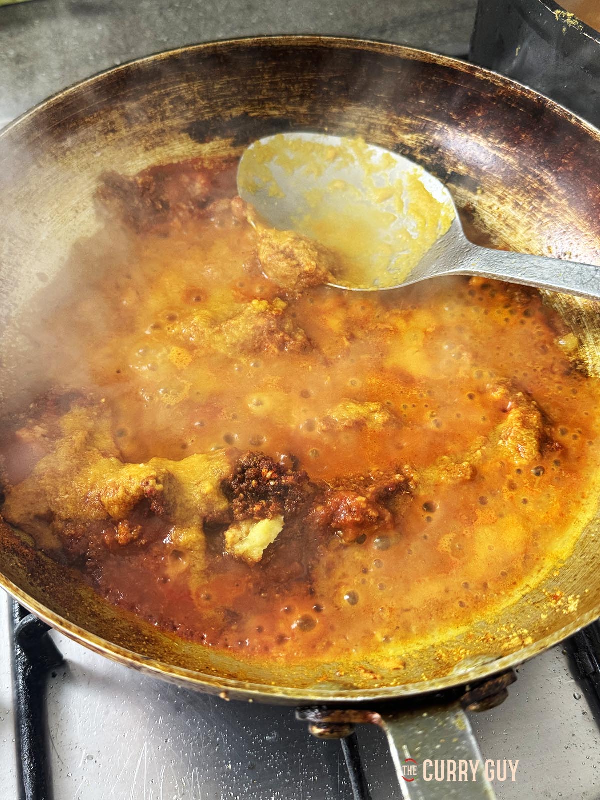 Adding the passata and a ladleful of the base sauce to the pan.