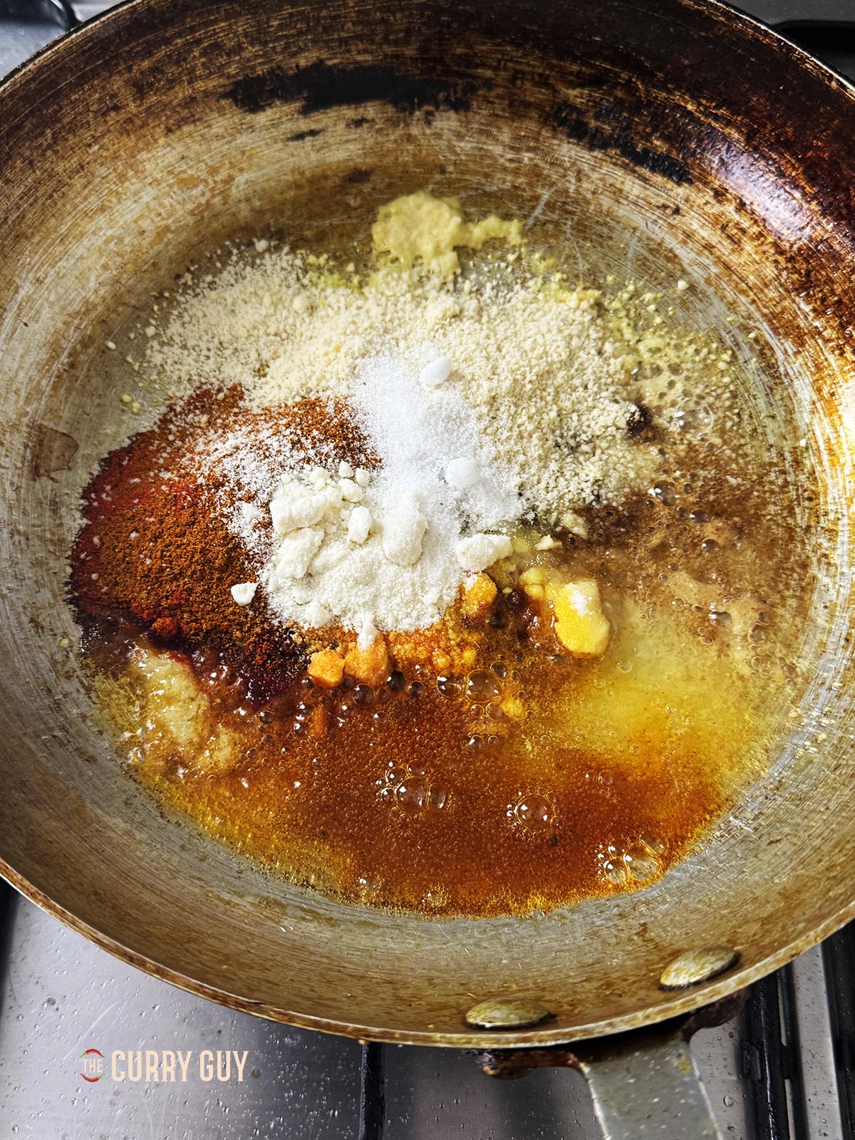 Stirring the paprika, mixed powder, tandoori masala, coconut flour and ground almonds.