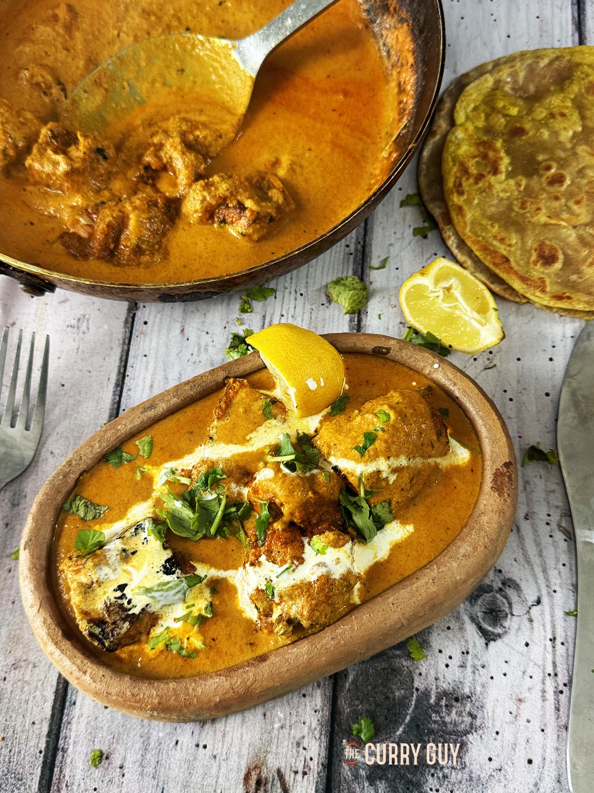 Salmon tikka masala garnished with cream and chopped coriander (cilantro).