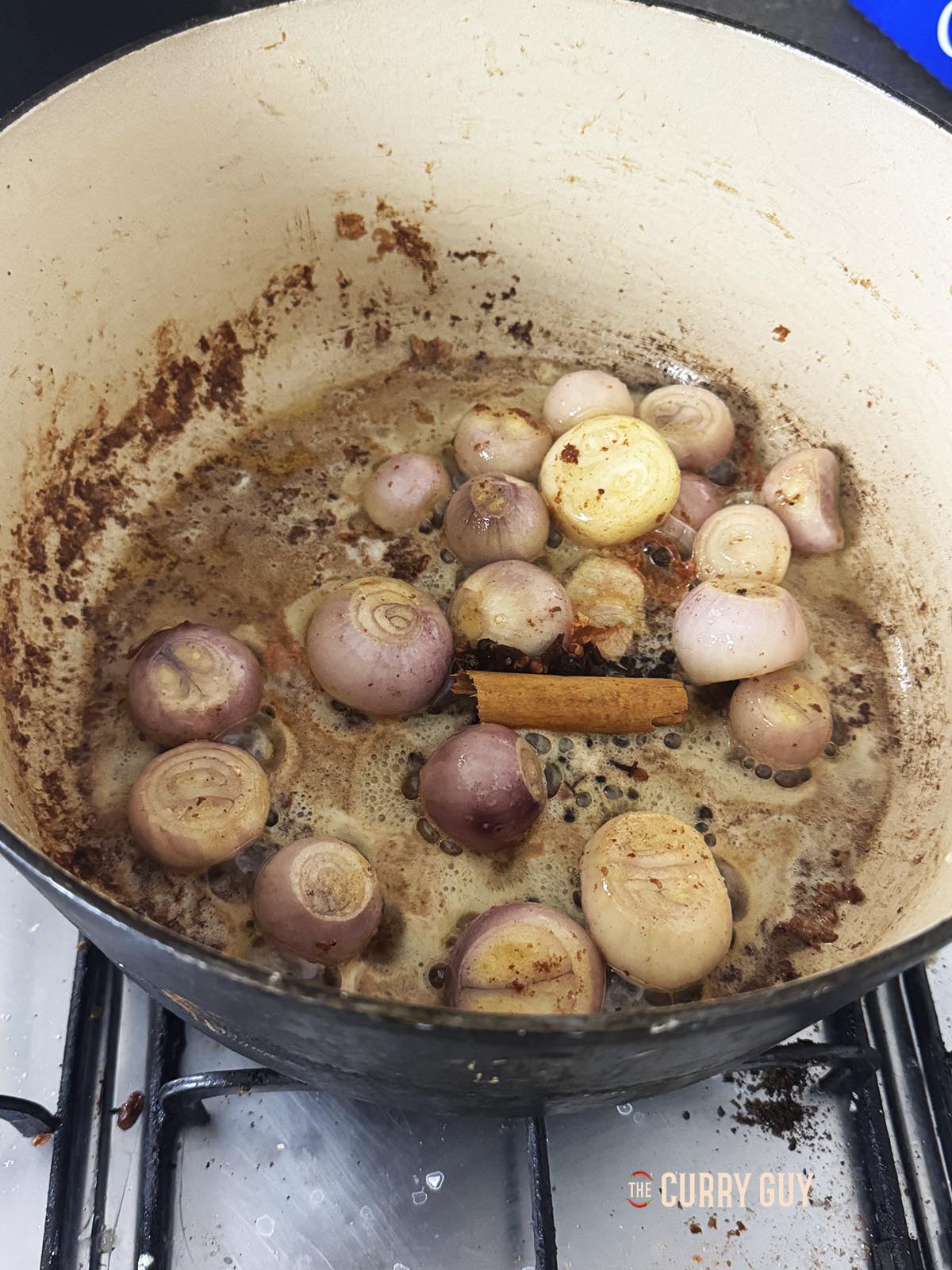 Adding the diced onions, garlic, pearl onions and spices to the pot.
