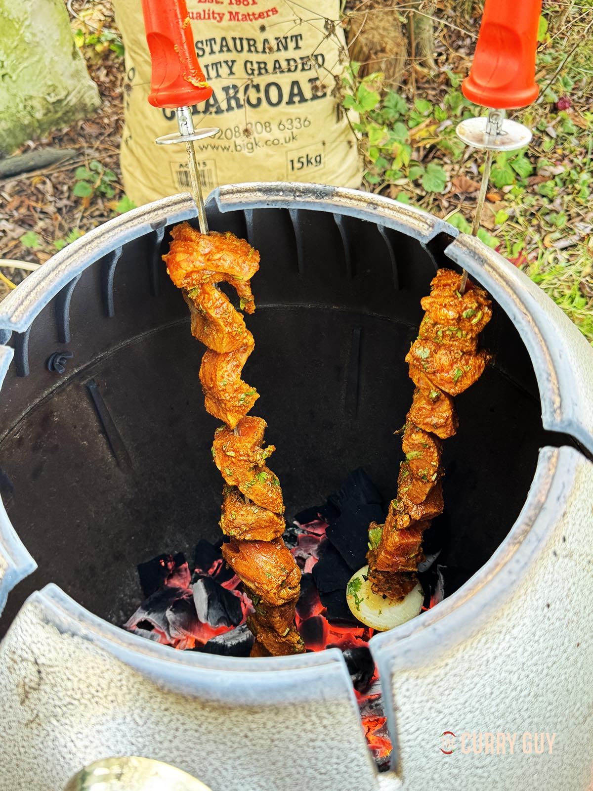 Placing the salmon skewers in a tandoor oven to cook. 