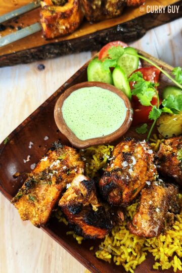 Tandoori salmon tikka on a bed of pilau rice and served with coriander and chilli raita.