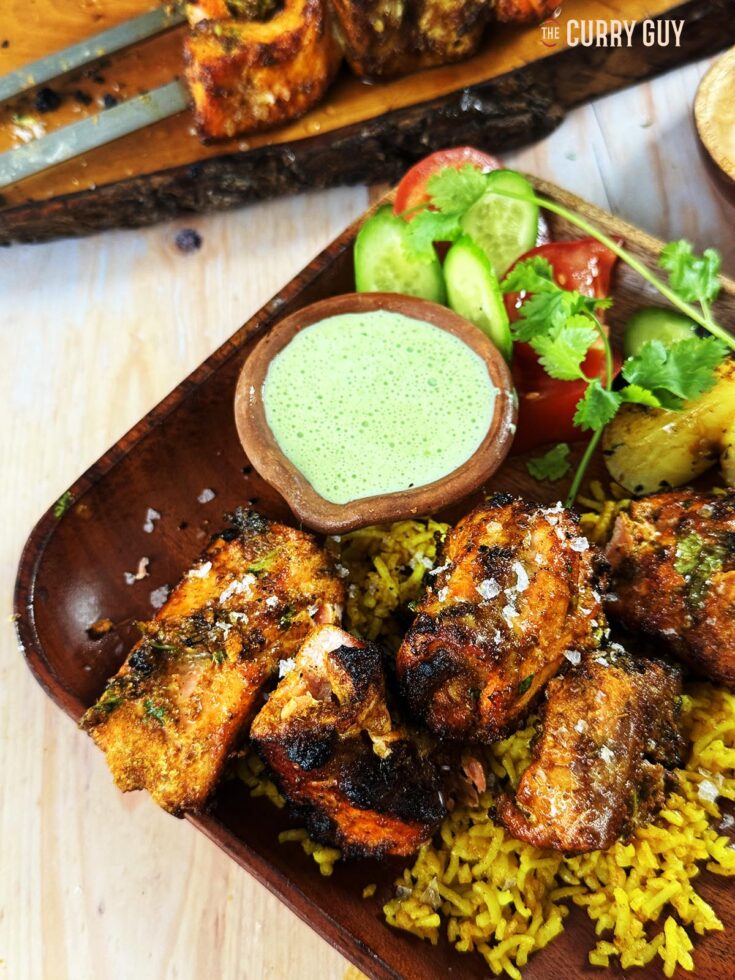 Tandoori salmon tikka on a bed of pilau rice and served with coriander and chilli raita.