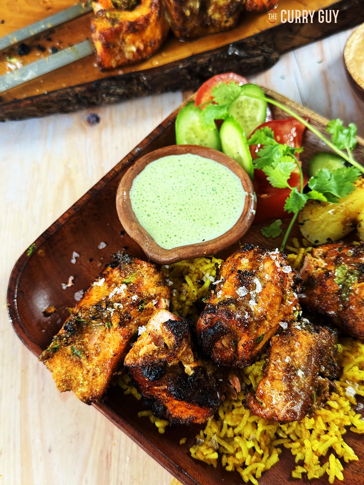 Tandoori salmon tikka on a bed of pilau rice and served with coriander and chilli raita.