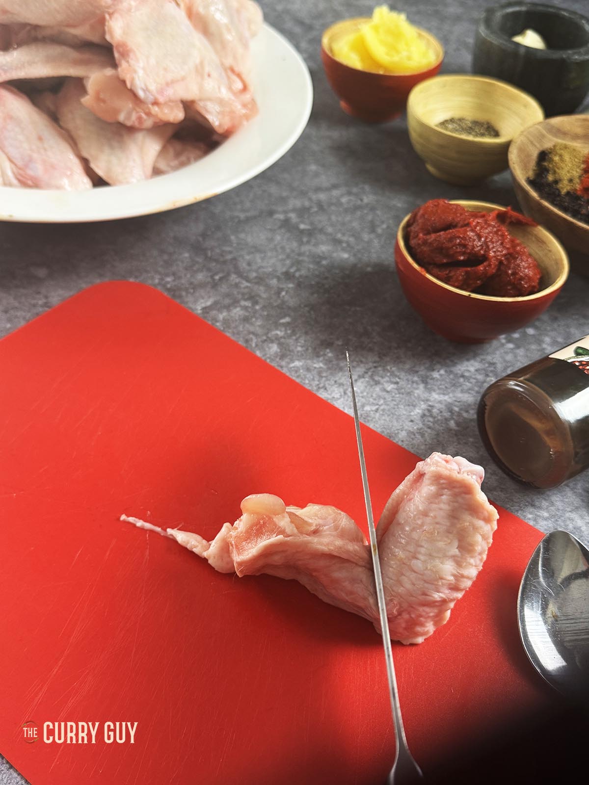 Slicing a chicken wing through the joint.