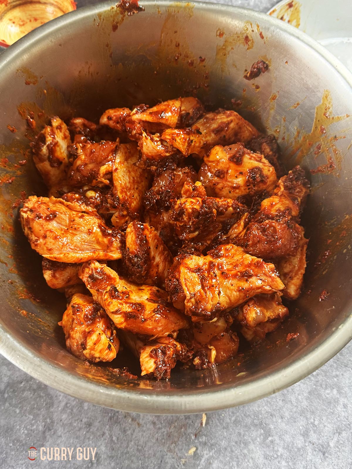 Marinating the chicken in a bowl.