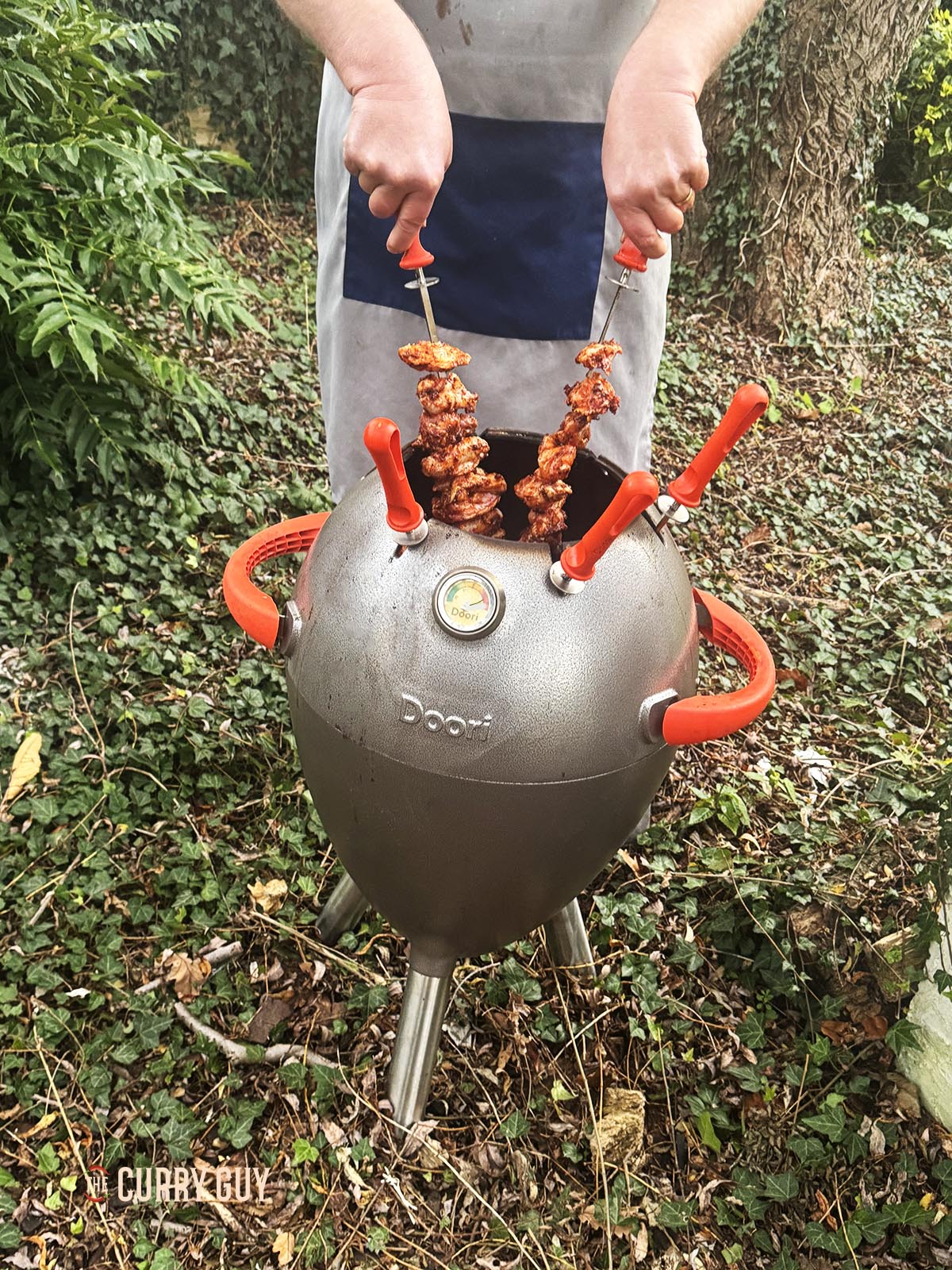 Placing the chicken skewers in a tandoor oven to cook.