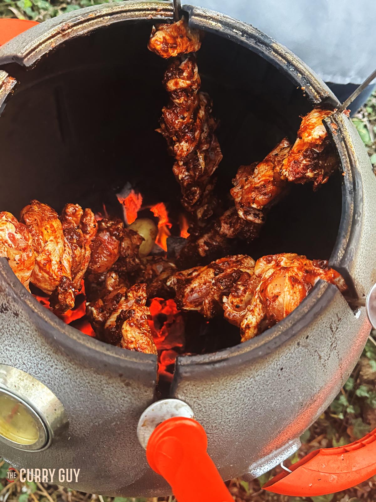Cooking the chicken wing skewers in a tandoor oven.