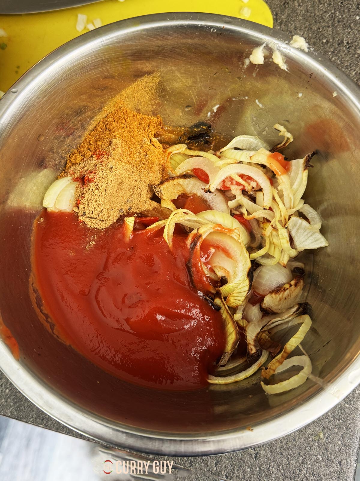 The air fried onions and bell pepper with the remaining sauce ingredients in a mixing bowl. 