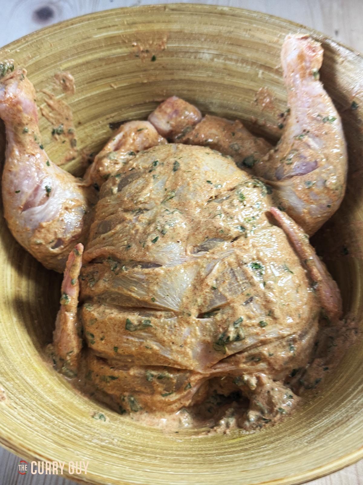 The chicken marinating in a bowl.