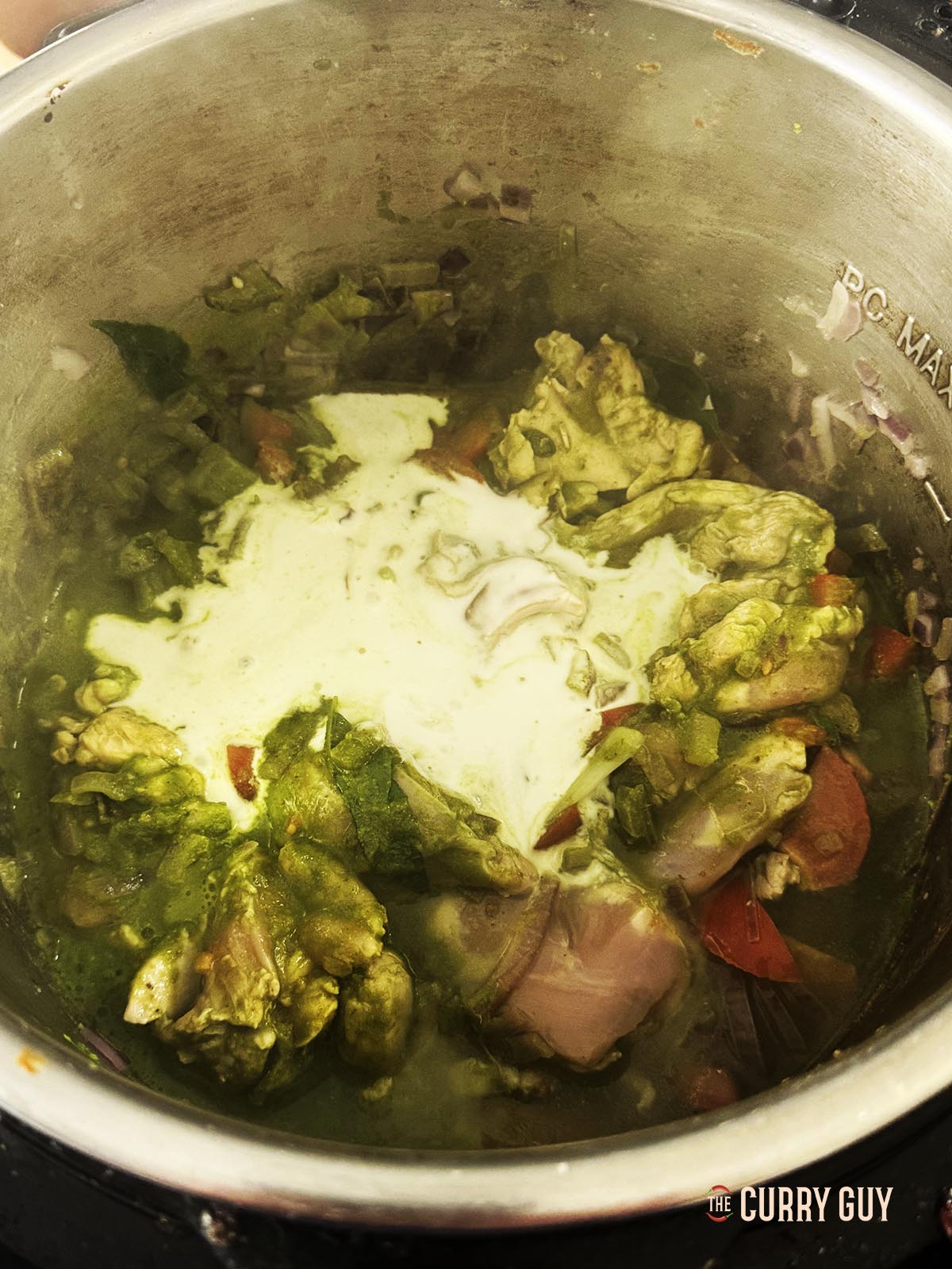 Stirring the coconut milk into the sauce.