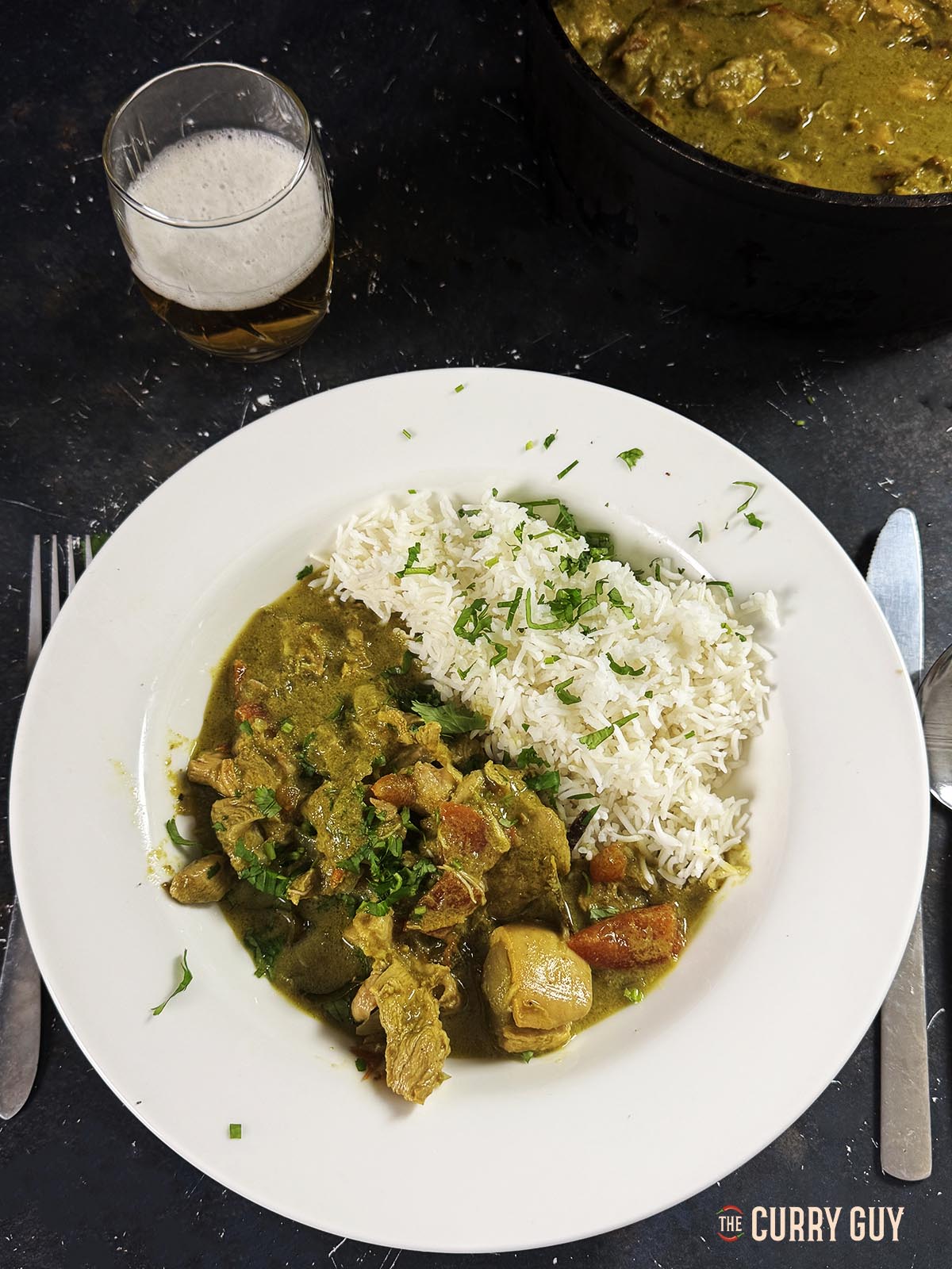 The slow cooker spicy chicken curry on a plate with a side of Basmati rice.