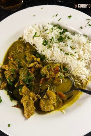Slow Cooker Chicken Curry on a plate with a side of white Basmati rice.