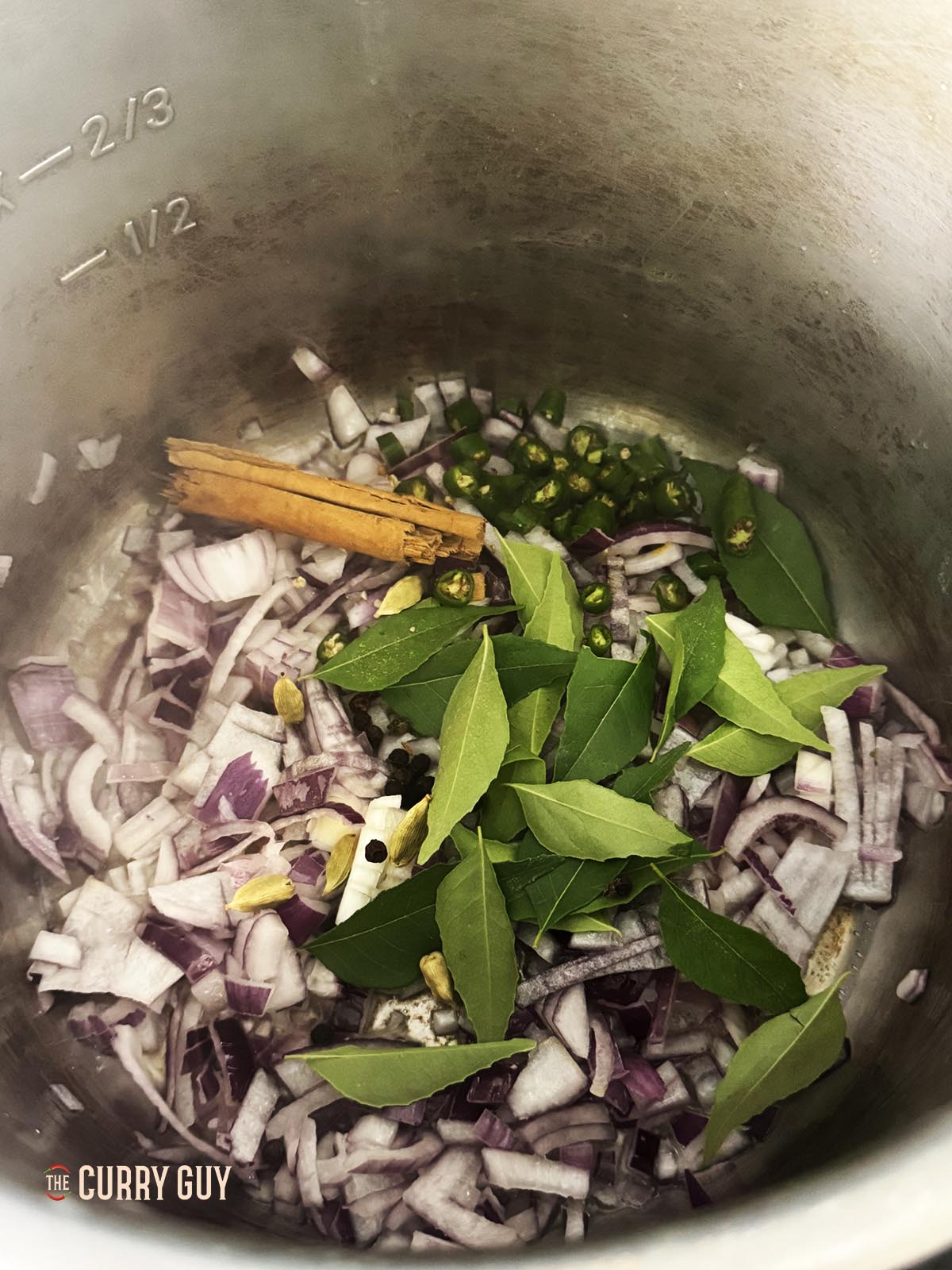 Frying the onions, whole spices and curry leaves using the searing feature of a multi-cooker.
