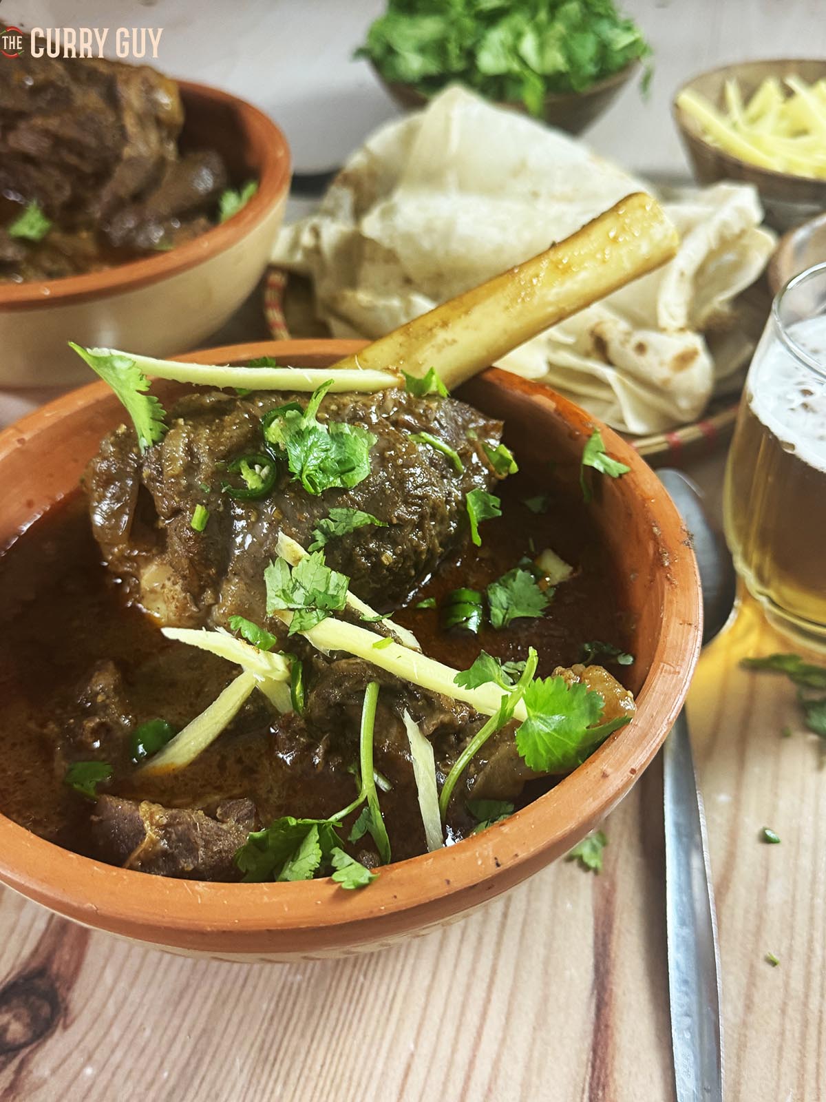 The slow cooker beef nihari in a serving bowl with garnishes.