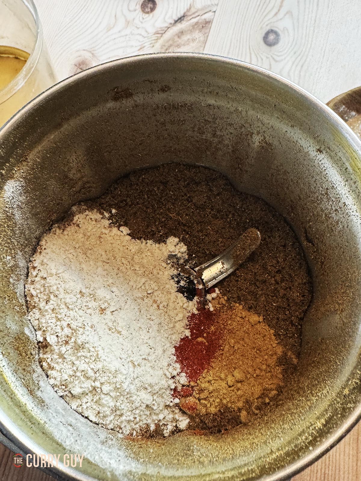 Adding the paprika, chilli powder, ground turmeric and chickpea flour to the ground spices.