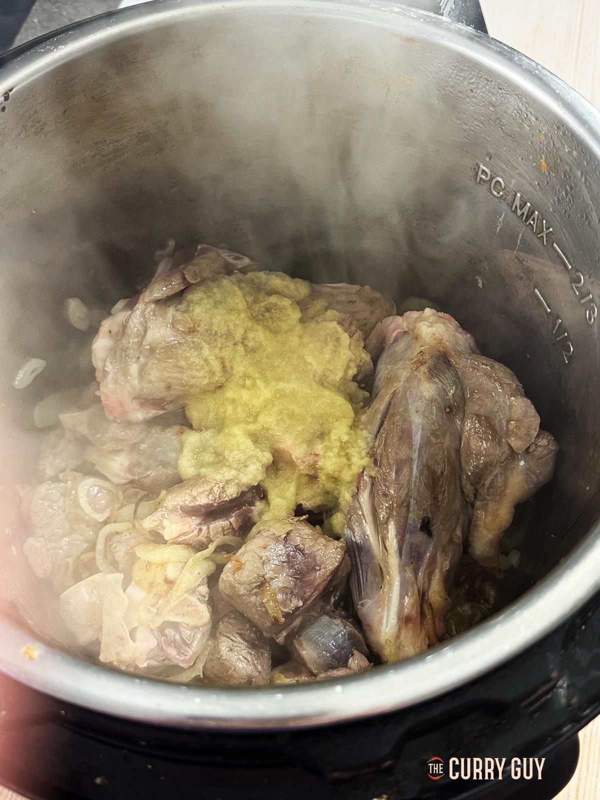 Adding the garlic and ginger paste to the pot.