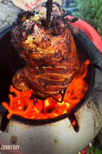 Finishing cooking the tandoori roast pheasant in the tandoor oven.