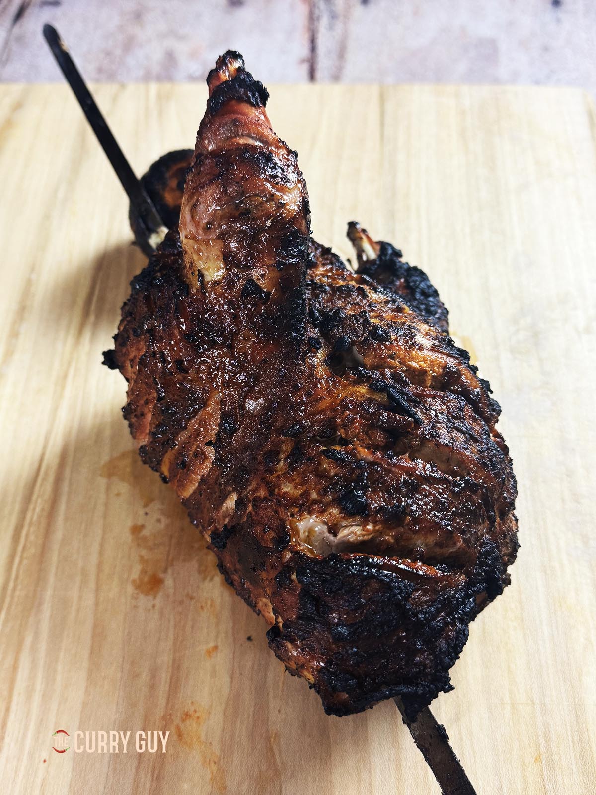 The cooked tandoori roast pheasant on a cutting board.