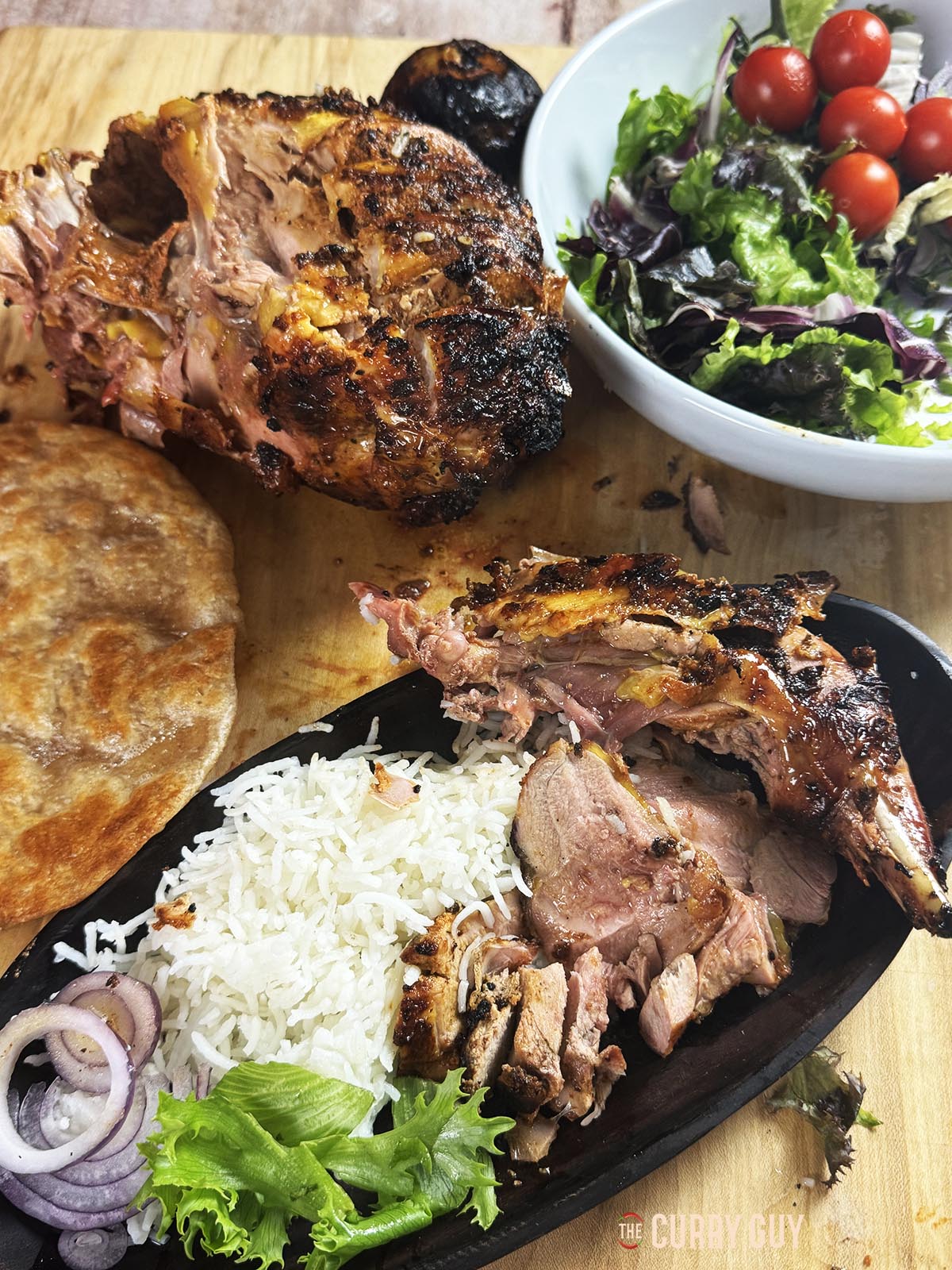 Tandoori roast pheasant on a serving plate with rice and salad vegetables. 