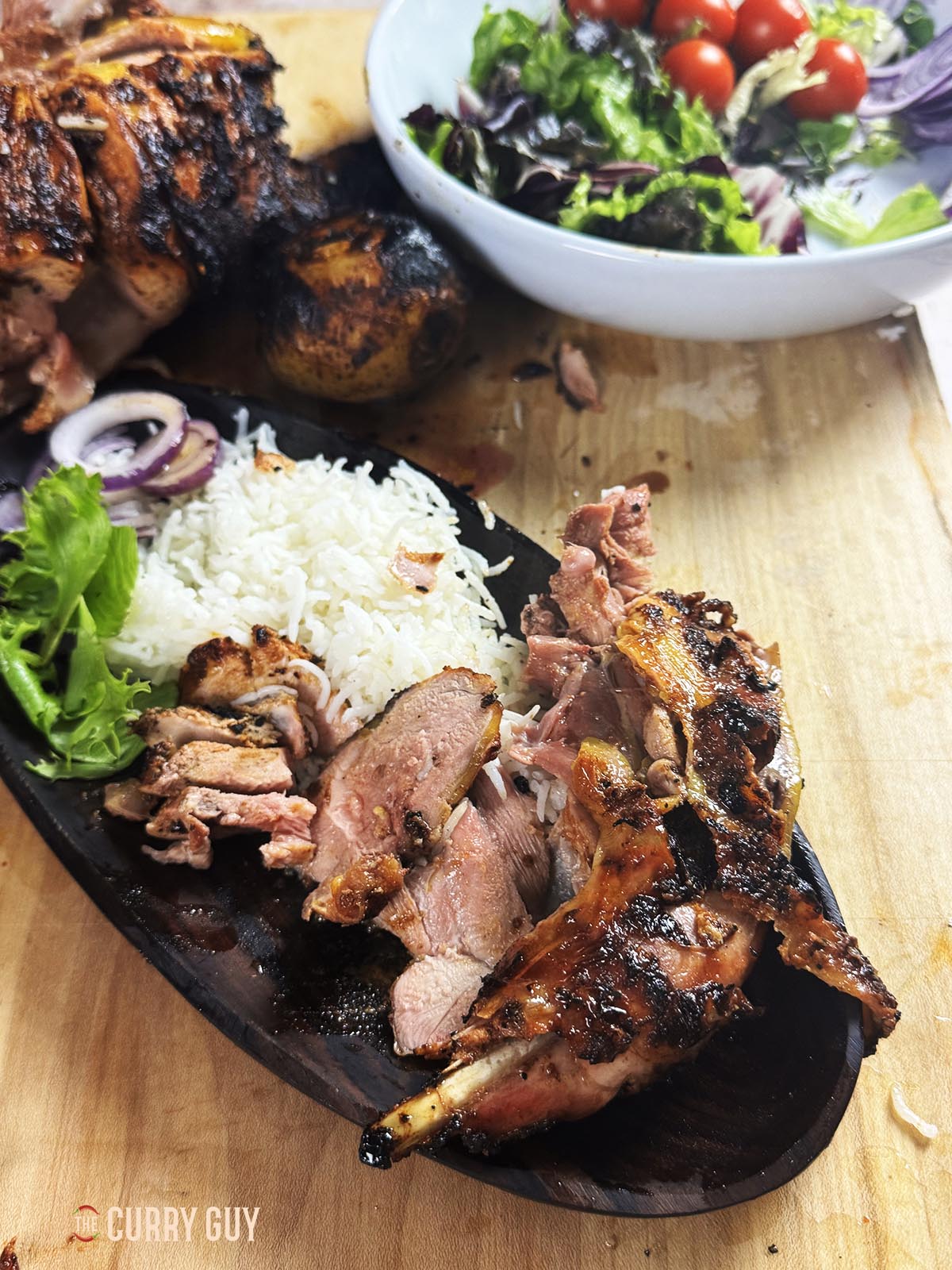 Tandoori roast pheasant on a serving plate with rice and salad.