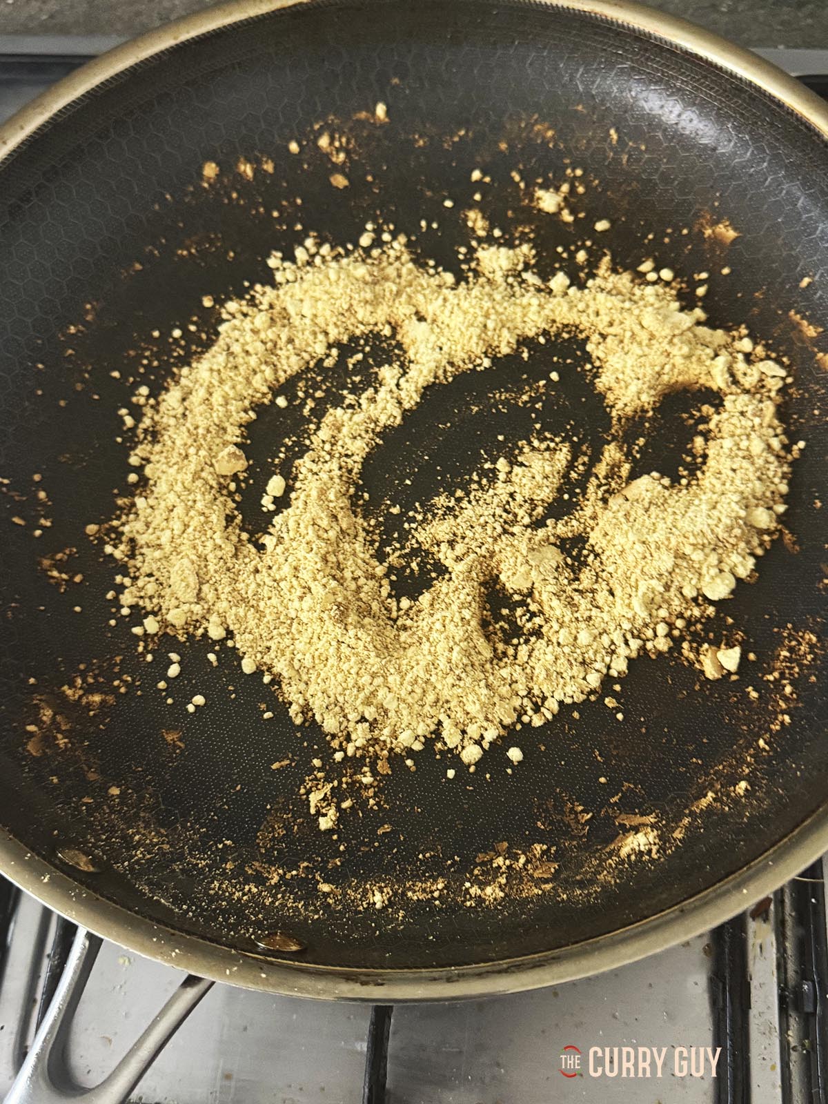 Toasting gram flour in a pan to add to the marinade. 