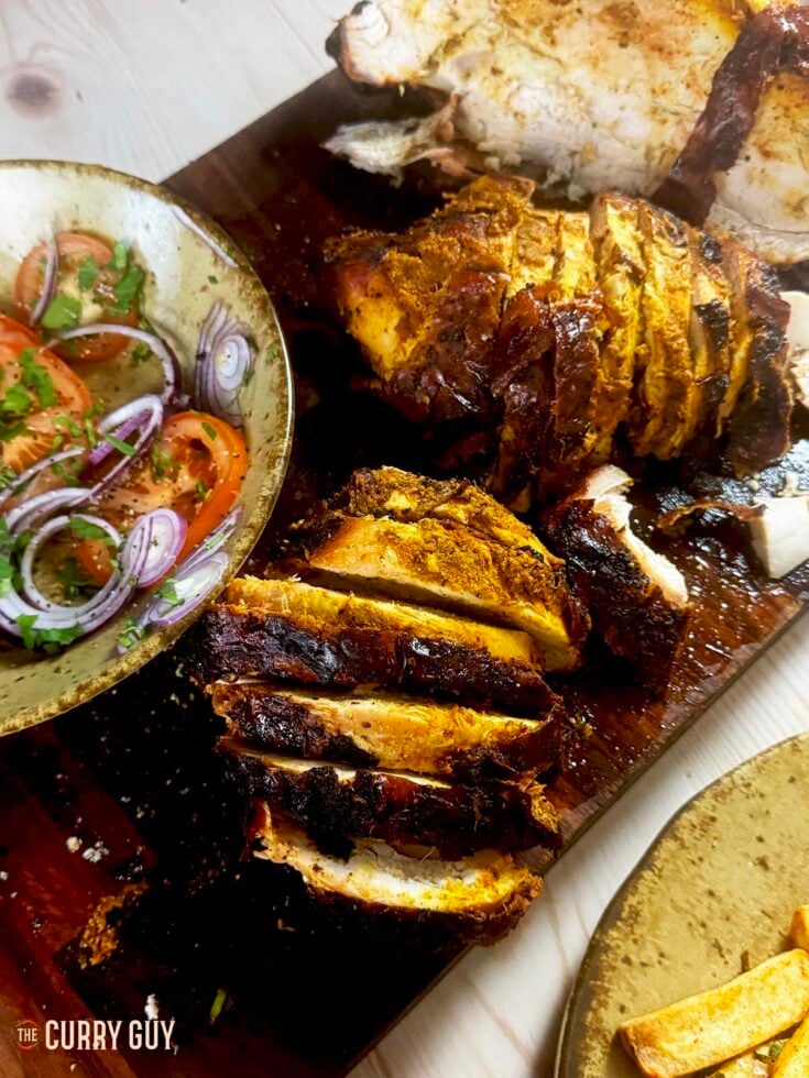 Tandoori turkey crown, sliced and ready to serve.