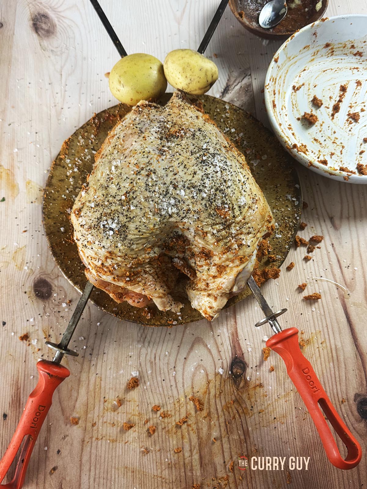Skewering the turkey crown for cooking in a tandoor oven.
