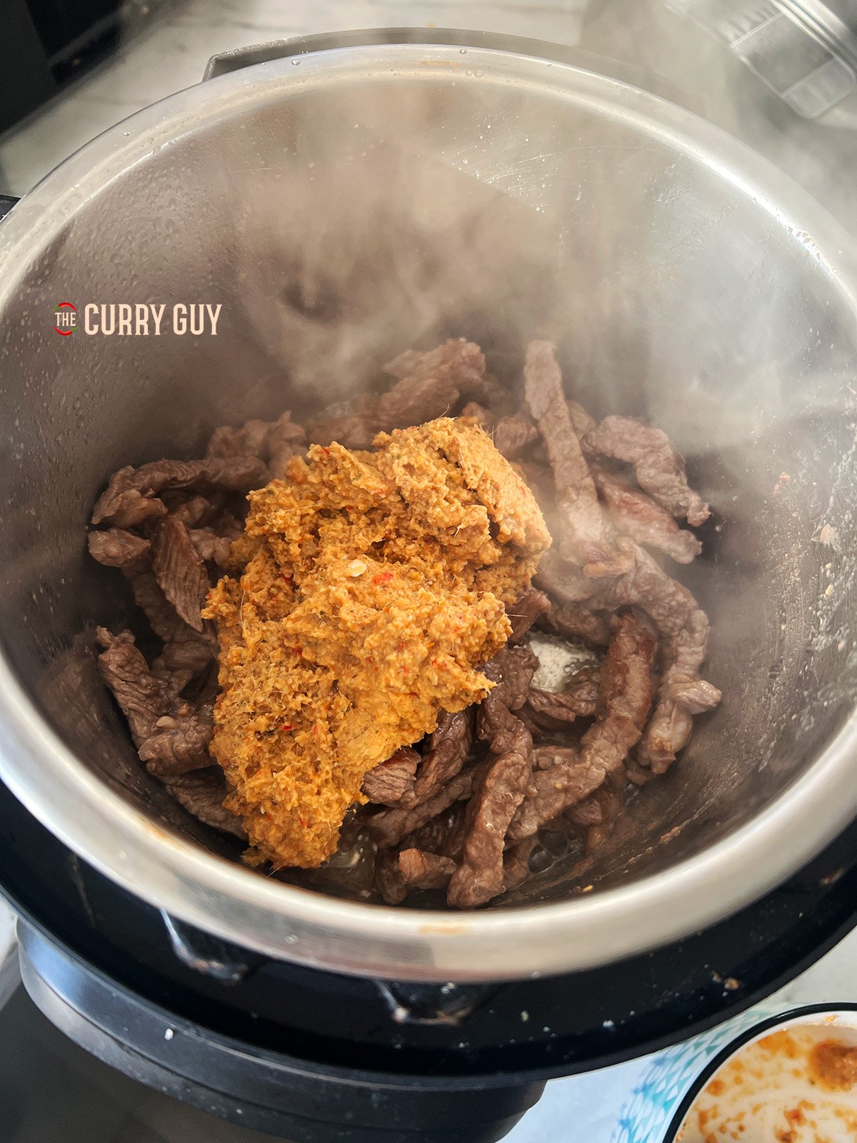 Panang curry paste added to the pan