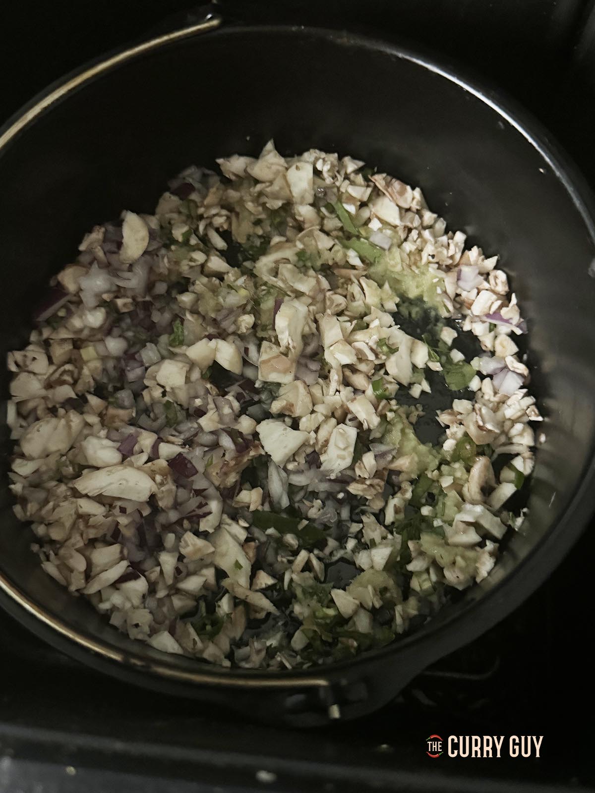 Placing the stuffing ingredients in a cake tin with oil to air fry.