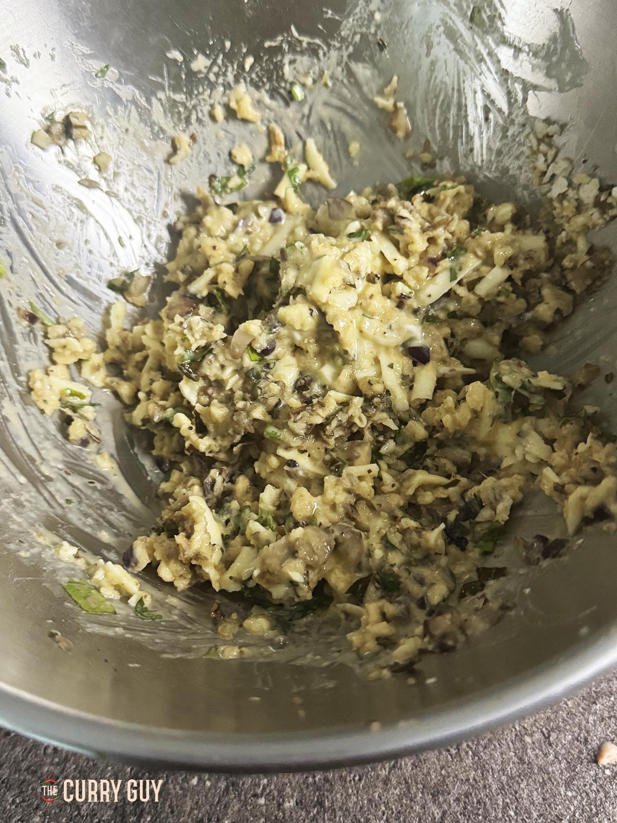 Adding the egg and cream cheese mixture to the bowl.