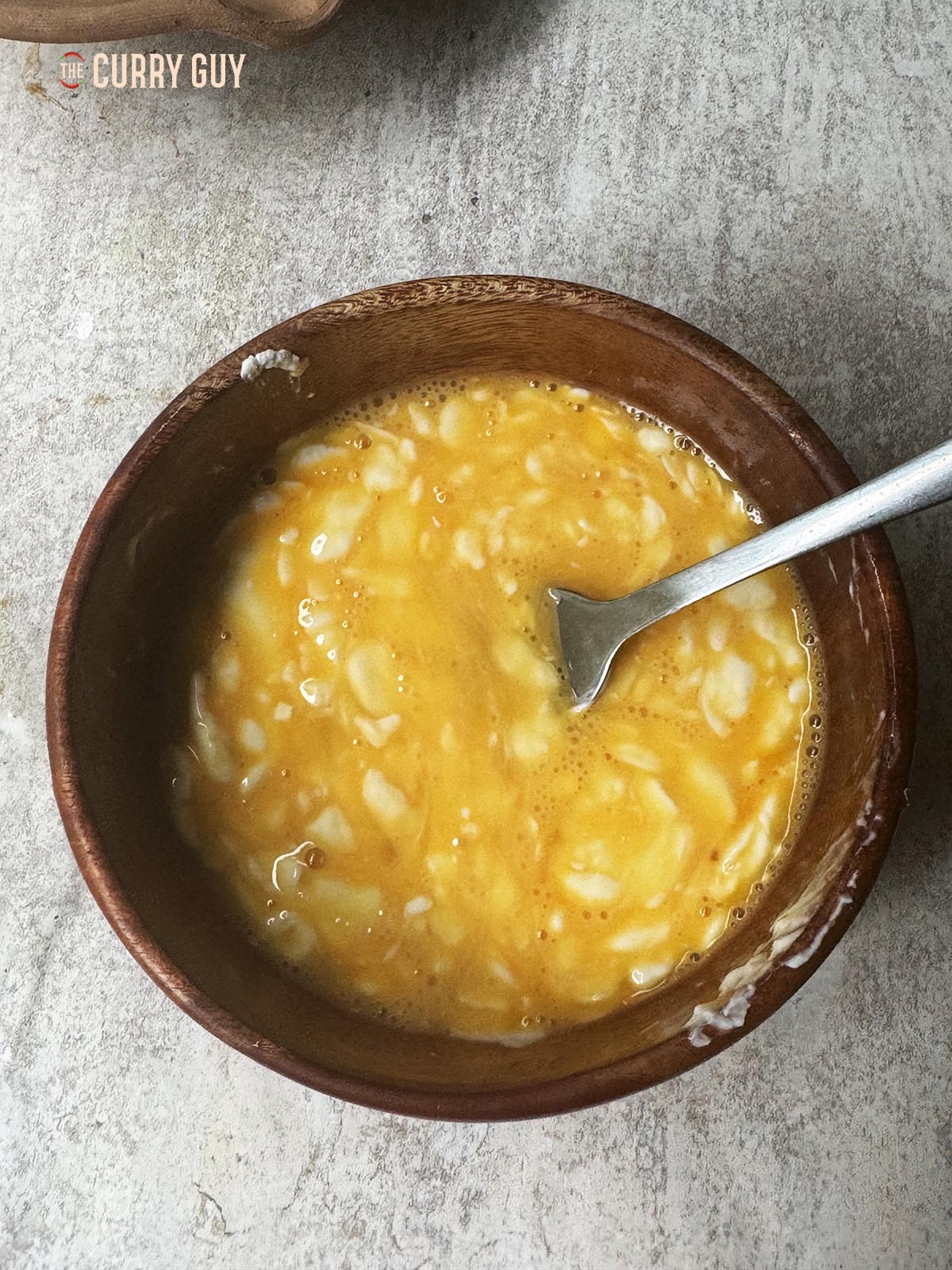 Whisking the egg and cream cheese together until smooth.