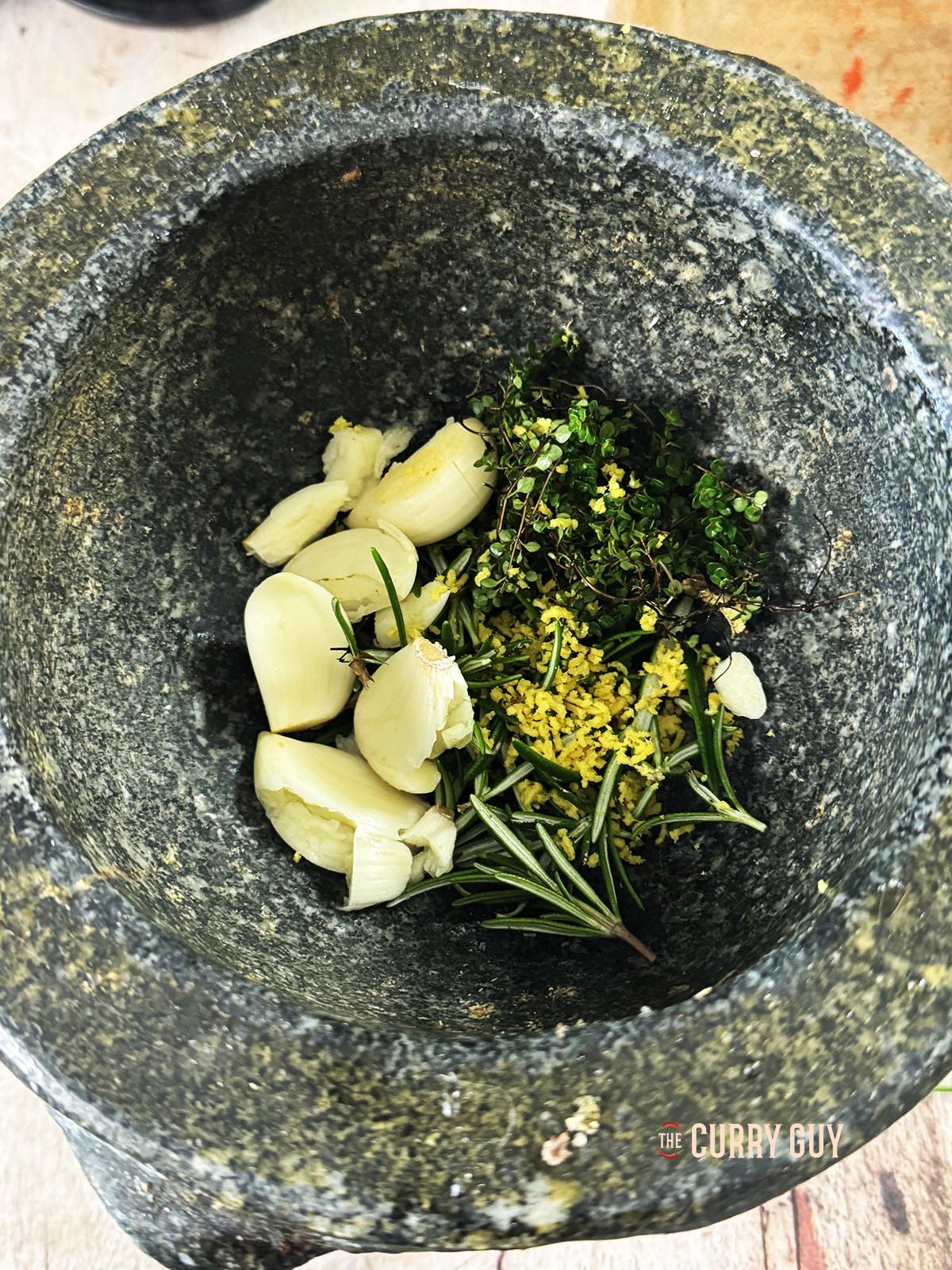 The garlic, herbs and lemon zest in a pestle and mortar.