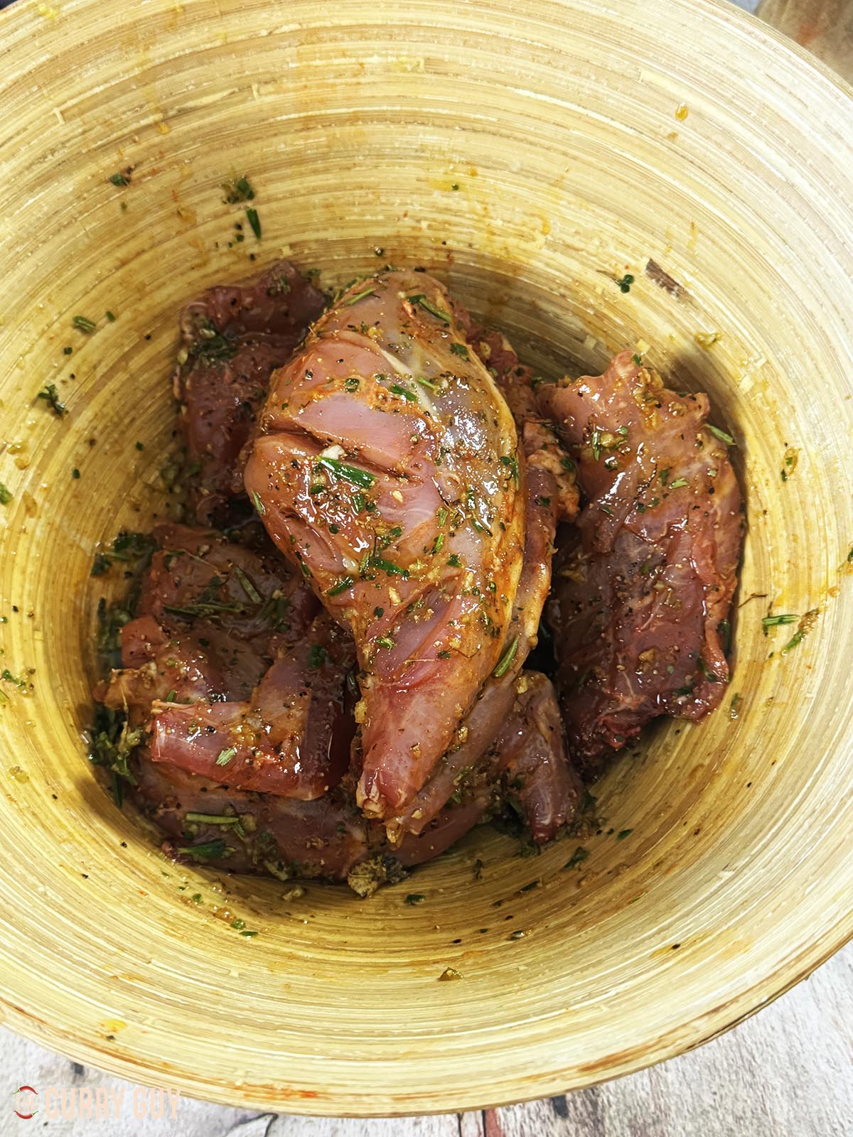 The rabbit pieces marinating in a bowl.